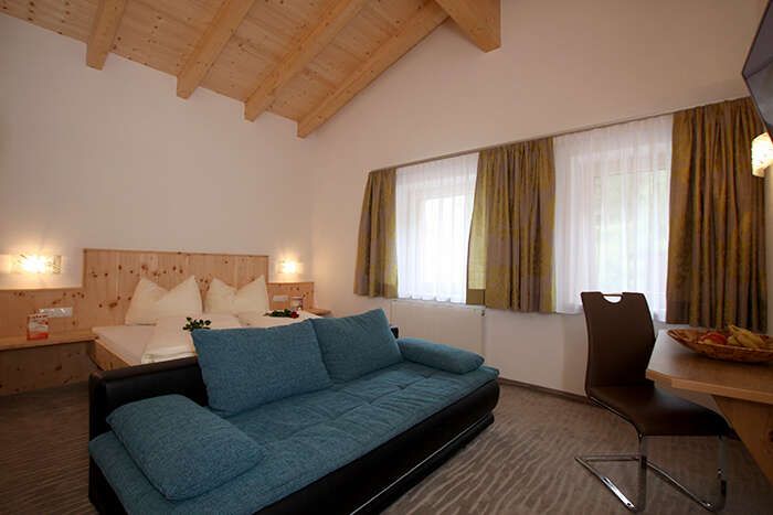 Doppelbett und Couch im Appartement 3 in Apart St Hubertus